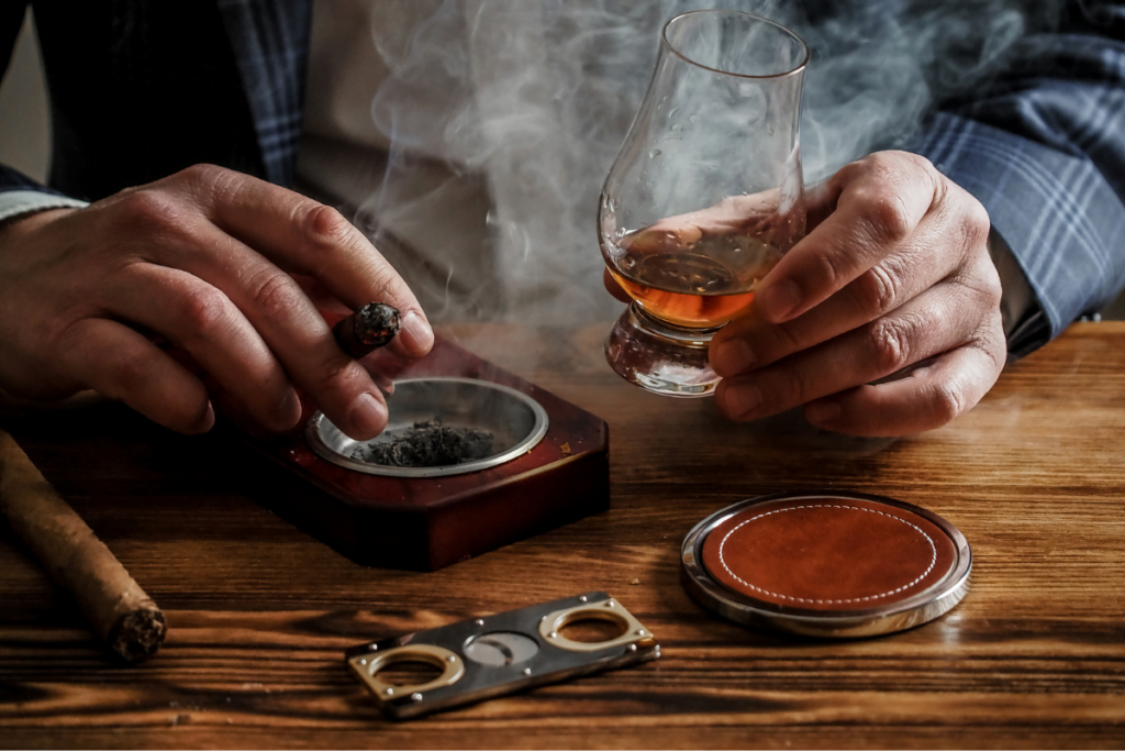 A man in a suit smoking a Habanos cigar on a wooden table.