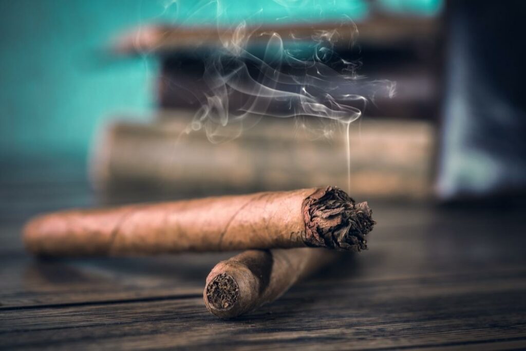 Cigars from various countries displayed on a wooden table.