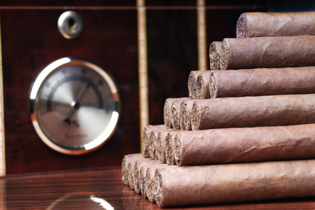 A stack of cigars next to an analog clock.