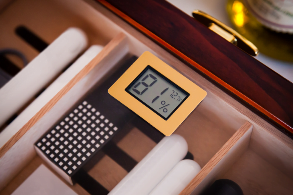 A wooden box with a digital hygrometer for storing cigars in a humidor.