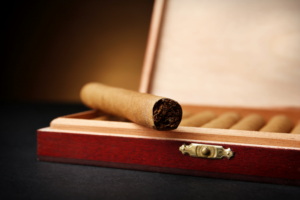Storing cigars in a wooden box on a dark background.