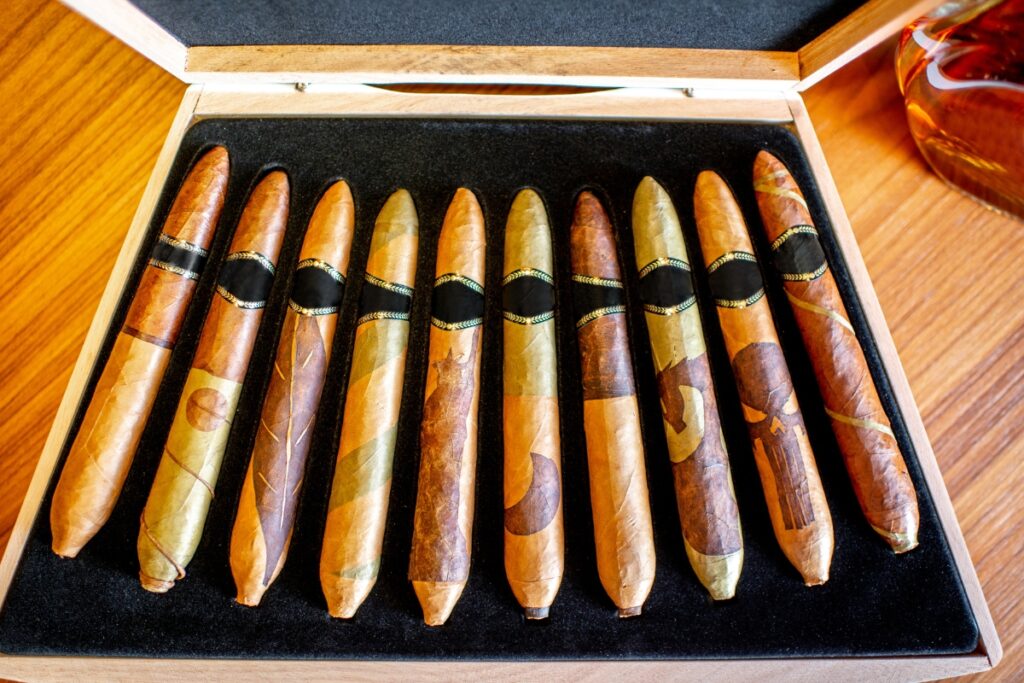 A collection of tasting cigars with various wrappers in a wooden box.