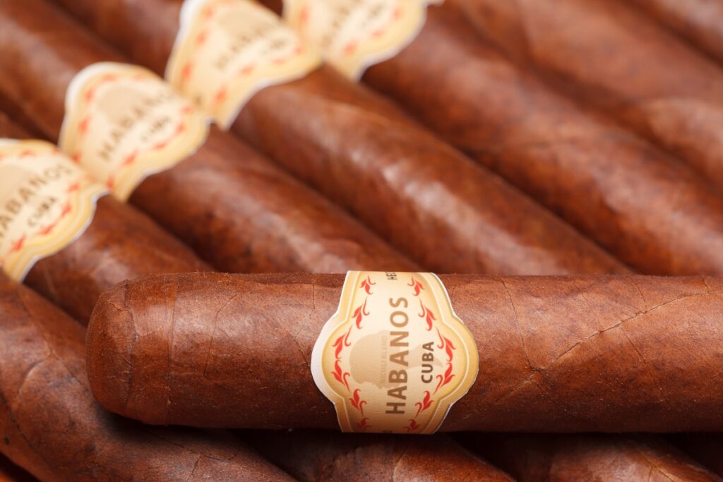 Close-up of a stack of Cuban cigars with a visible "habanos" label, showcasing the anticipation of tasting their complex flavors.