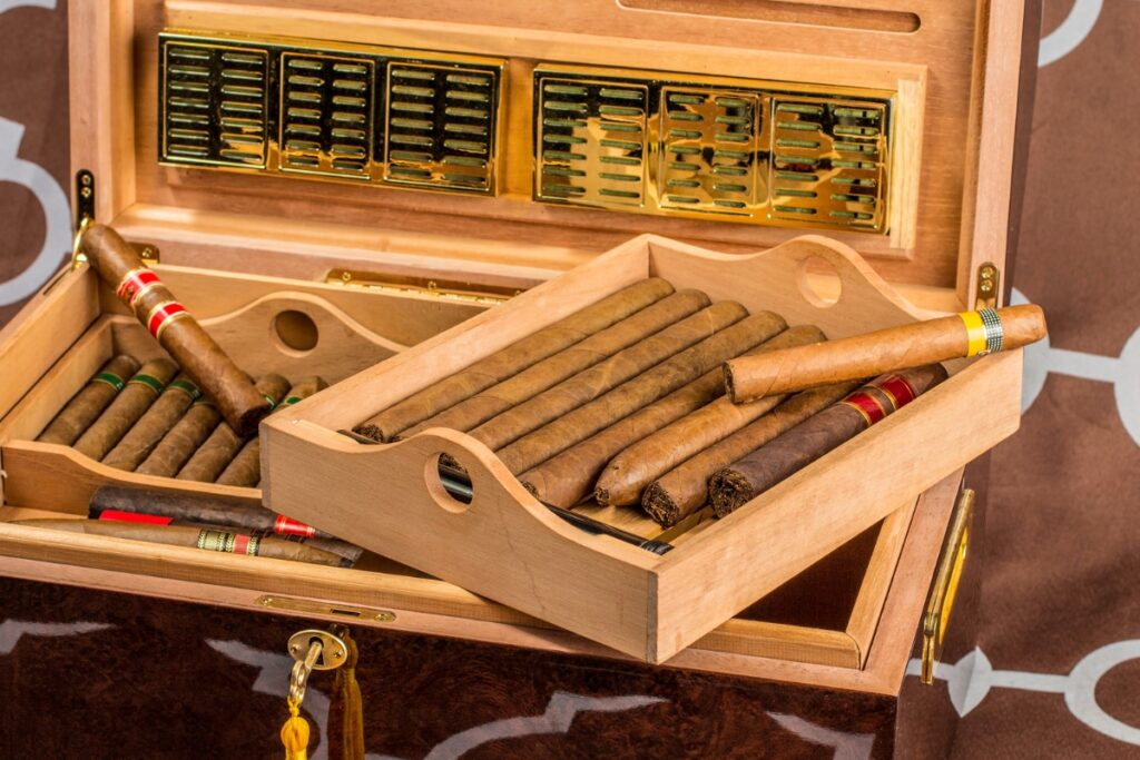Wooden humidor box with tasting cigars and a hygrometer.